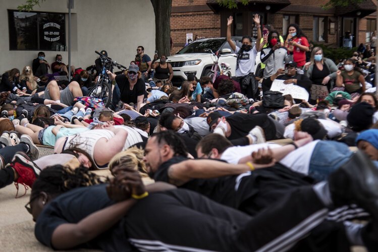 Protestors lie on the ground and chant, “I can’t breathe,” for nine minutes while others document during an event to protest the death of George Floyd and social injustice June 1 outside Isabella County Sheriff’s Office in Mount Pleasant, MI.