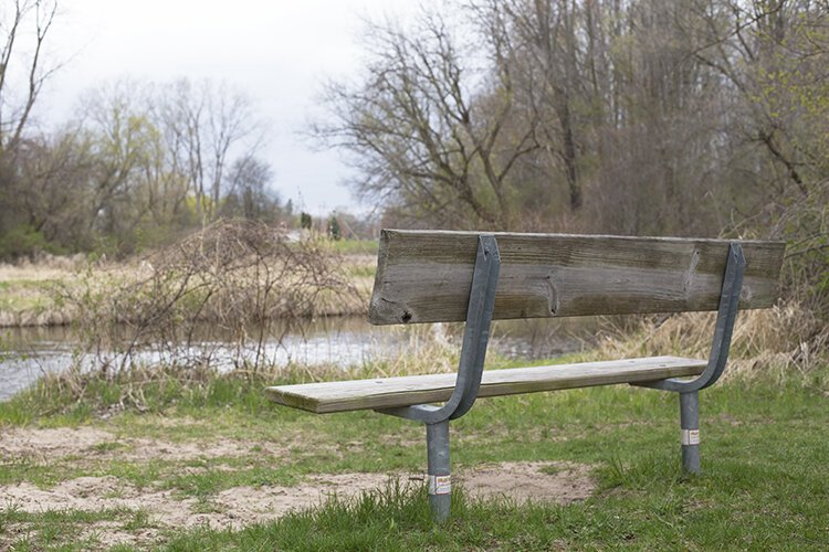 A bench along the GKB Riverwalk Trail in Mt. Pleasant offers visitors an opportunity to rest and enjoy the beauty of the Chippewa River.