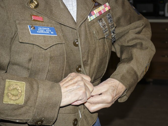 Ed Haynack buttons up his Army uniform from WWII.
