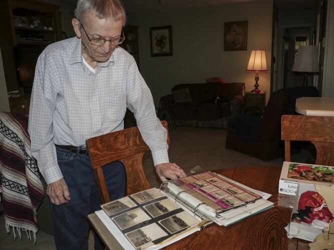 WWII veteran Ed Haynack, 91, looks at photos from his time in the Army.