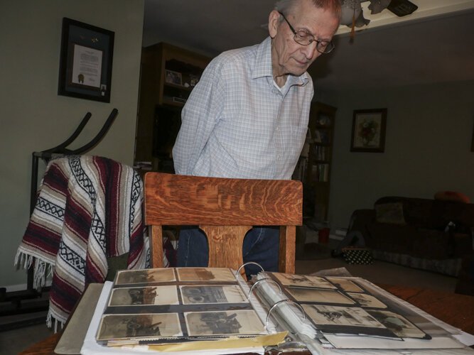 WWII veteran Ed Haynack, 91, looks at photos from his time in the Army.