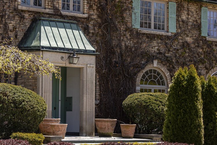 The entranceway of 711 South Fancher is sheltered by green roofing and is made of both concrete and brick. 