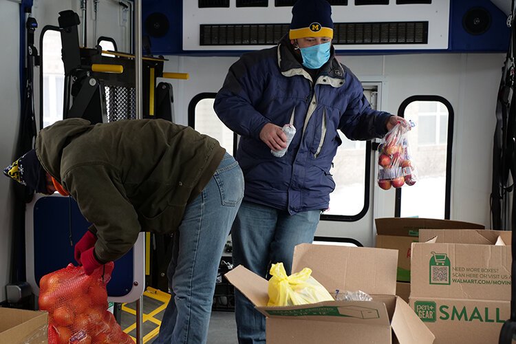 Aboard an I-Ride bus, volunteers Marc Cooper and Caleb Ross prepare a delivery from The Care Store.