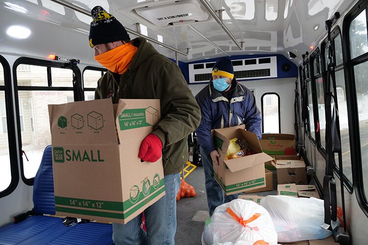 Volunteers aboard an I-Ride bus prepare to deliver boxes from The Care Store.