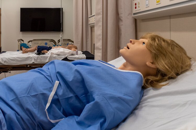 The mannequins of a pregnant women, infant, and young child lay in adjacent hospital beds in the IEPC.
