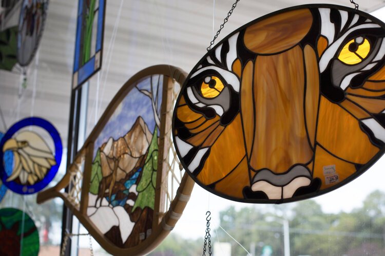 Stained glass art is displayed in the windows at Creatively! Glass & More.