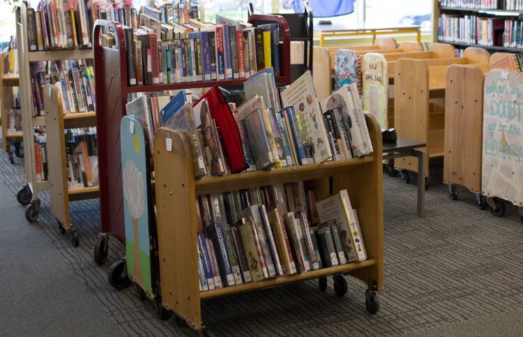 A section of the Veterans Memorial Library that used to be a seating area is being used as a space for materials that had been rented out. Upon return, they are quarantined for 72 hours before being reshelved.