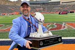 Dr. Benjamin Cox holds the 88th Annual Tony the Tiger Sun Bowl Championship trophy while standing in the Sun Bowl stadium in El Paso, Texas on Dec. 31, 2021.