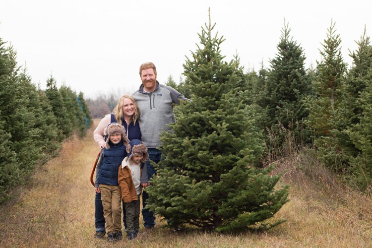 The Rudy family pose for a photo next to their Christmas tree, a 7-foot Fraser Fir that they cut down at Vander Sys Tree Farm Nursery, in Weidman, Michigan.  Sally and her husband James with their children Logan (left), 7, and Connor, 5.