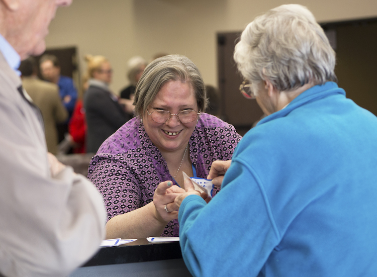 Volunteer receptionist Renee Benner greets visitors as they arrive for The Strickler Nonprofit Center open house on Thursday, April 5, 2018. 