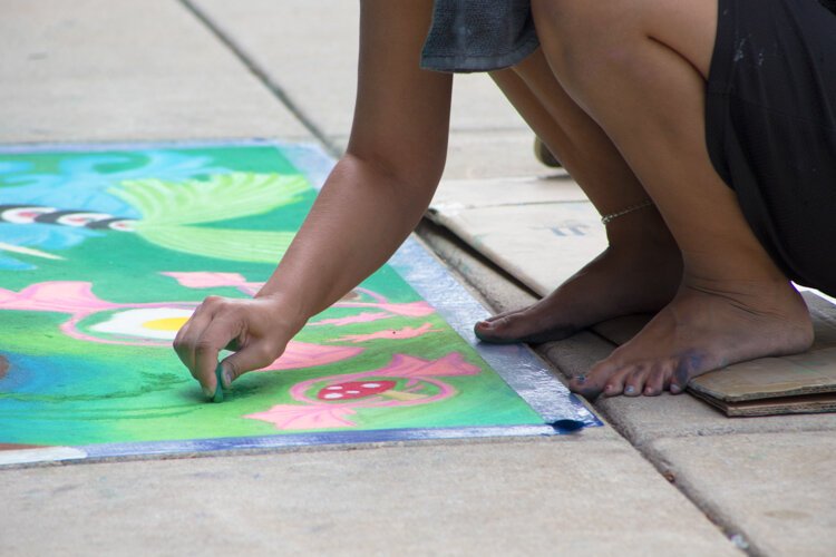 Chalk the Walk artist Malia Reger touches up her artwork before it is judged.