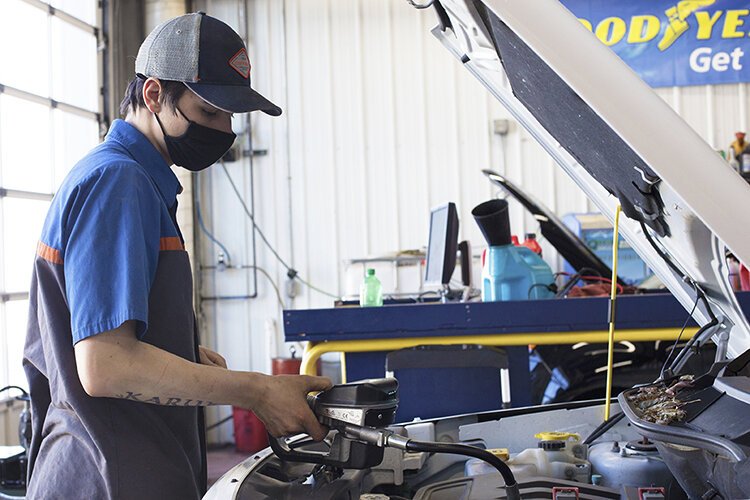 Christopher Bartown, a lube technician at Quick Lane Tire & Auto Center at Krapohl Ford & Lincoln, works on a car on Friday, Jan. 29 during a fundraising event at the center for the Humane Animal Treatment Society. 