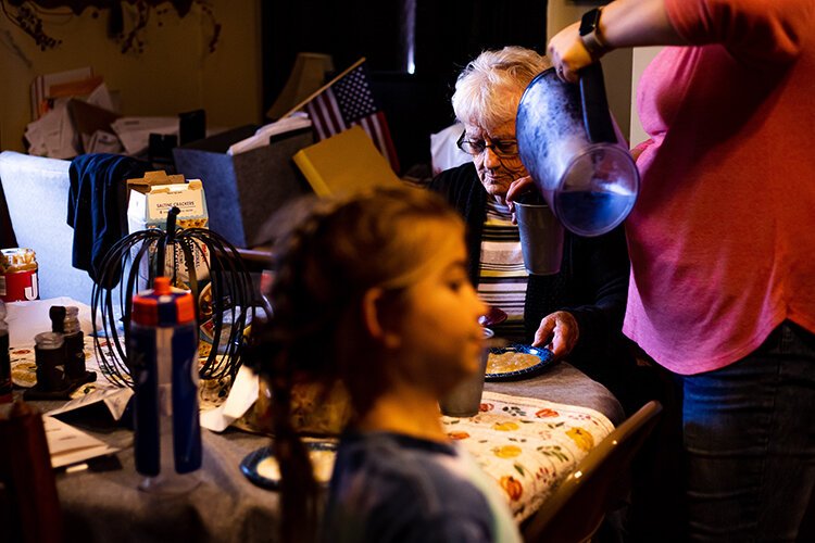 Megan Little, 35, pours water for her grandmother, Mary Ann Verwey, 88, after serving her the homemade chili and applesauce Becky made for dinner. 