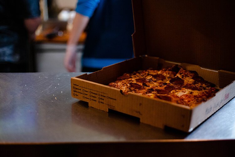 A finished pizza is placed on a counter in The Cabin before making its way to customers.