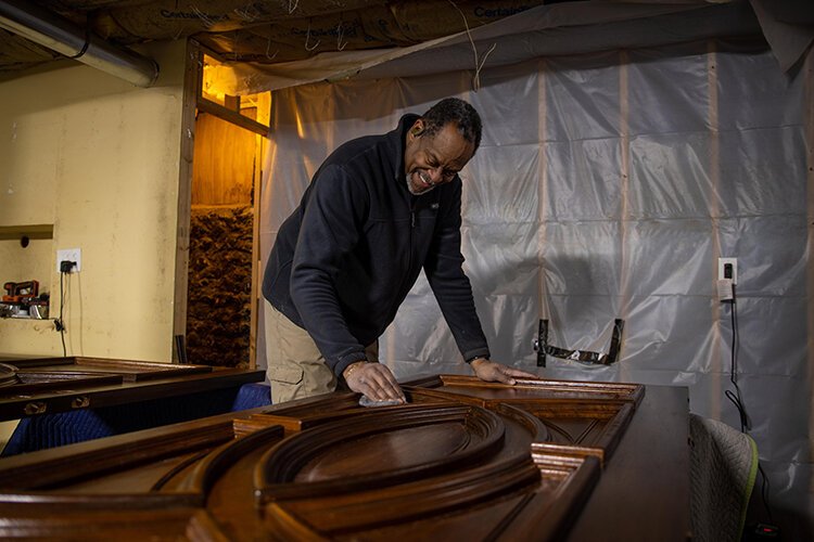 Ken Williams works in the basement refinishing the front door of his historic home on S. University Street.