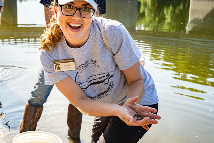 Meaghan Gass, Michigan Sea Grant Extension Educator with MSU Extension with a sturgeon for release.