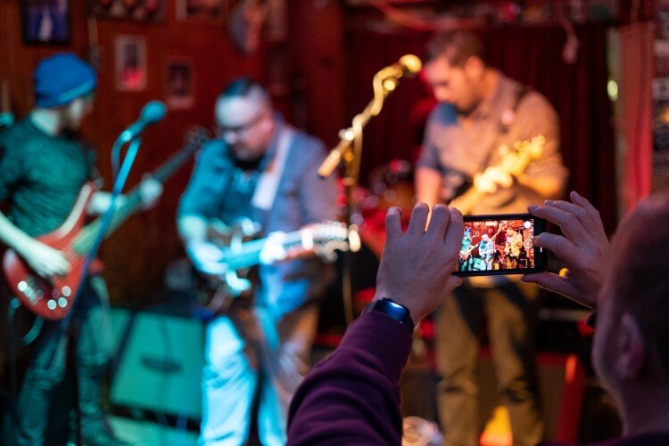 A patron takes a video of the entertainment at White's Bar