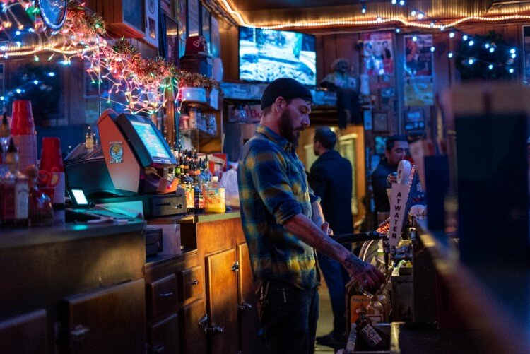 A bartender works during a recent night at White's Bar