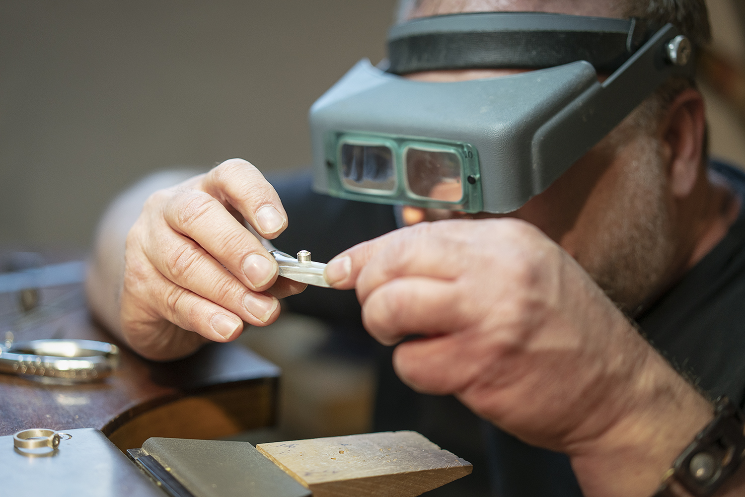 Flint, MI - Tuesday, May 8, 2018: Flint resident and metalsmith Robert McAdow inspects a setting in a pendant he is creating.