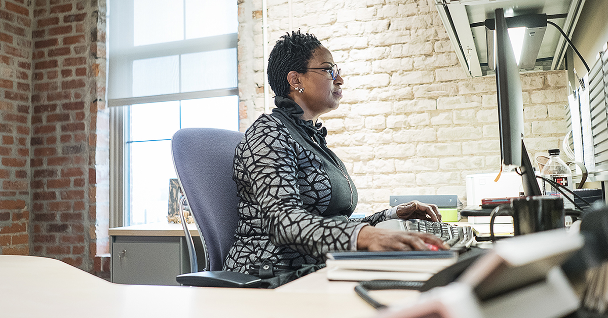 Flint, MI - Thursday, November 2, 2017: Detroit resident Denise Smith, 55, sits at her office desk in the Community Foundation Building addressing emails and taking care of tasks for the day. Smith, the Executive Director for the Flint Early Childhoo