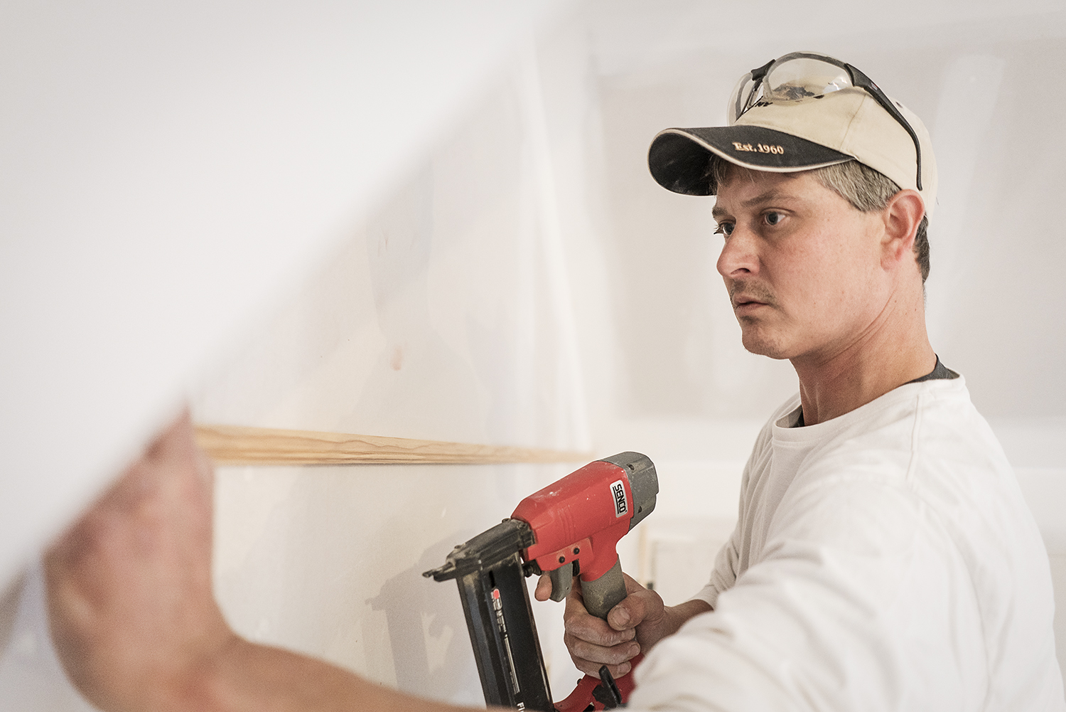 Flint, MI - Tuesday, October 31, 2017: Carpenter and Oxford resident Rob Smith, 43, secures a strip of trim to the wall before cutting and hanging bead board below it, on the third floor of the Whaley Historic House Museum.