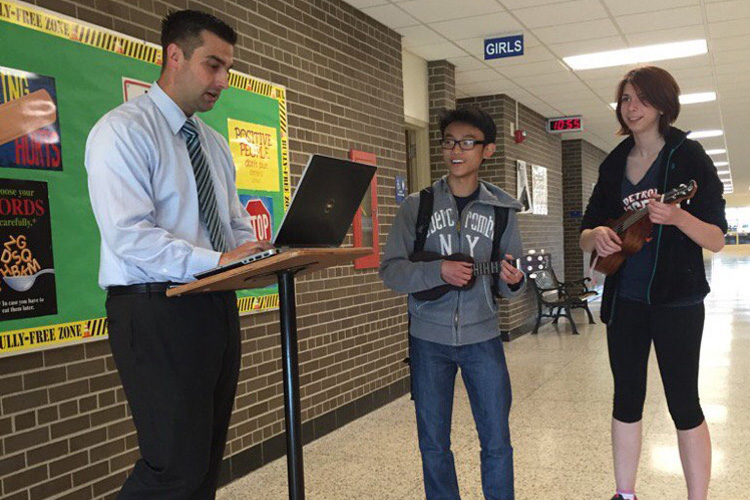 John Bernia, left, works to further digital education.