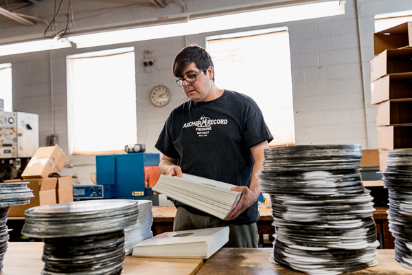 Andrew Garcia, Floor Manager at Archer Records, packaging completed records