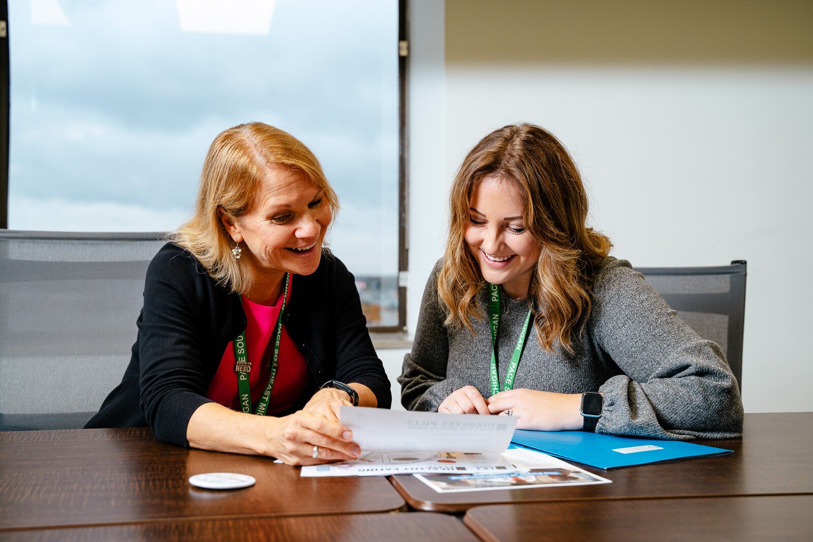 Laurie Arora, PACE Southeast Michigan vice president of public affairs, philanthropy, and organizational development; and Sadie Shattuck, PACE Southeast Michigan's grant and communications specialist, look over health literacy handouts.