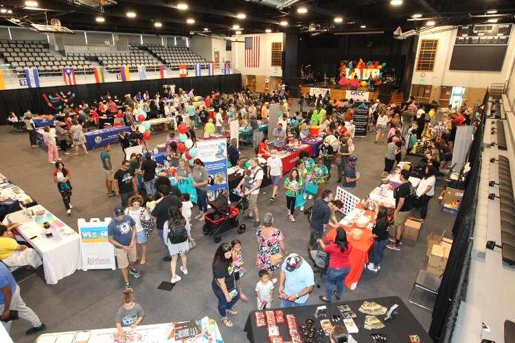 Visitors attending the LAUP ¡Fiesta! walk along the Mercado vendor tables in the Holland Civic Center on July 9.