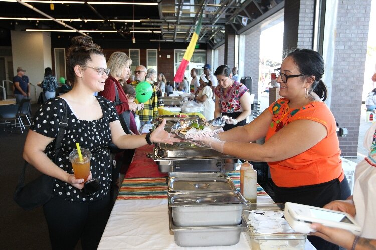 Cassie Loomis, a grad student of Western Theological Seminary, receives her order of tacos from Jacqueline Navarrete, manager of Mi Favorita Grocery in Holland, in the Festival Mercado section of the International Festival of Holland. (J.R. Valderas)