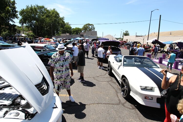 Visitors walk among the automobiles on display while attending the car show of the LAUP ¡Fiesta! in Holland July 9.