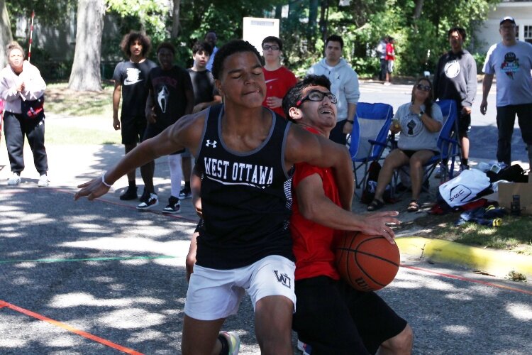 Students from Holland-area schools play basketball on 13th Street while competing in the Juneteenth Jump-Off 3-on-3 basketball tournament at Third Reformed Church in Holland, Michigan, June 18, 2022.