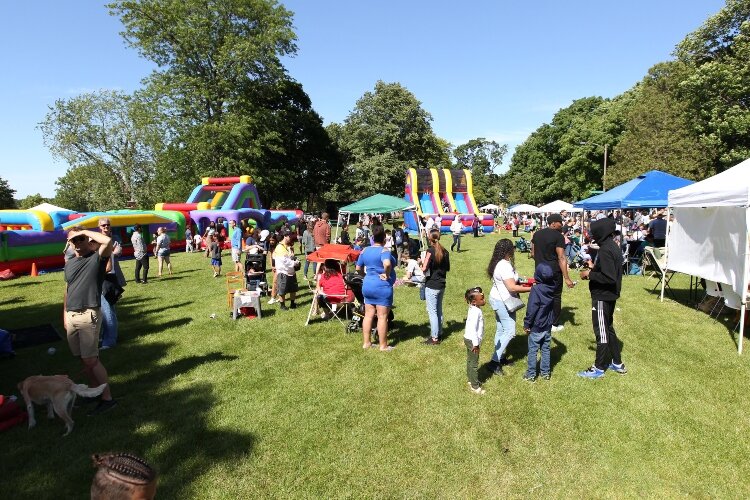 Visitors walk alongside the vendor booths in Kollen Park in Holland, Michigan while attending I AM Academy's Juneteenth Freedom Festival, June 18, 2022.