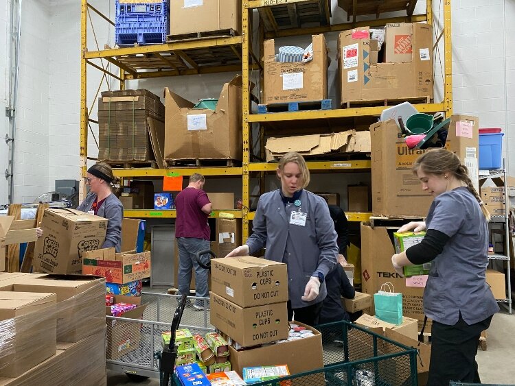 Staff and volunteers at Love In Action of the Tri-Cities sort food that will be distributed to those in need. 