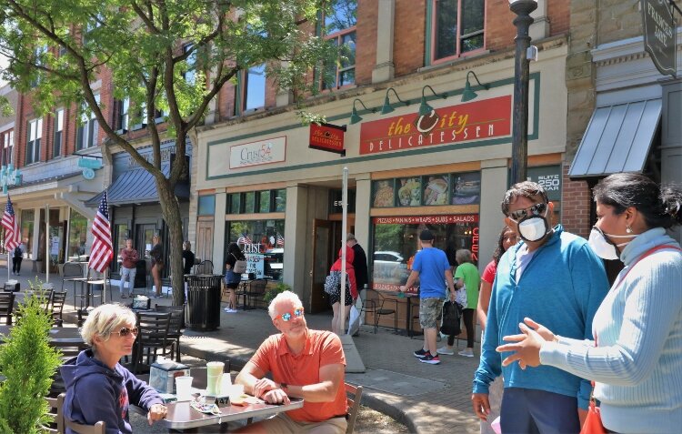 Holland Mayor Nathan Bocks and his wife Elizabeth take a break from their streetside lunch to greet downtown visitors.