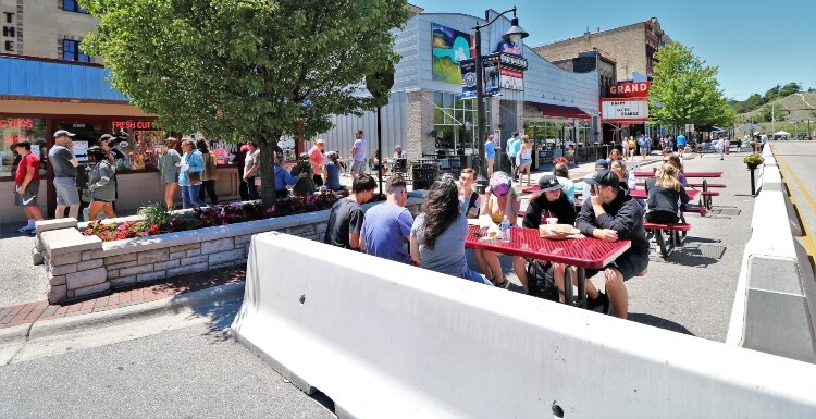 Downtown Grand Haven extends outdoor dining onto a barricaded section of a traffic lane along Washington Avenue.