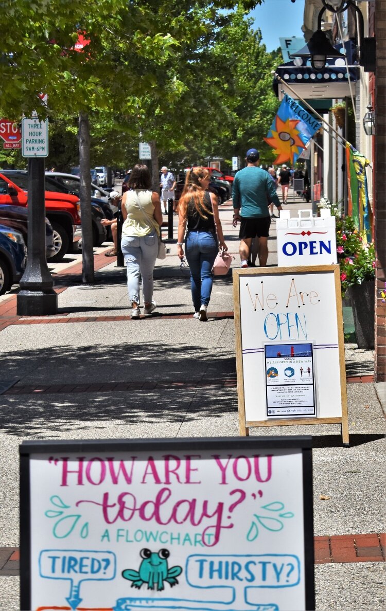 Signs in downtown Grand Haven leave no doubt that the central business district is open for business again.