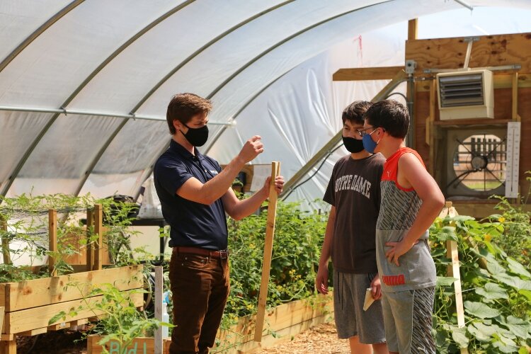 Gentex engineer Elliot Busta volunteers weekly at the Holland Middle School greenhouse, teaching students about STEM.