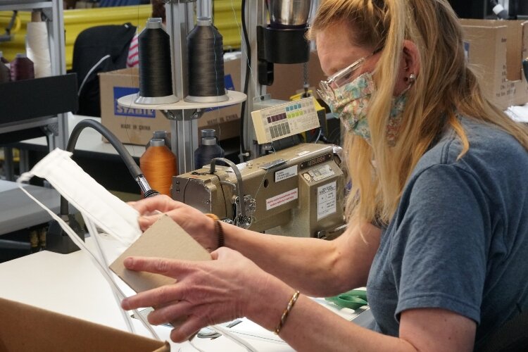 Herman Miller employee works on a mask. 