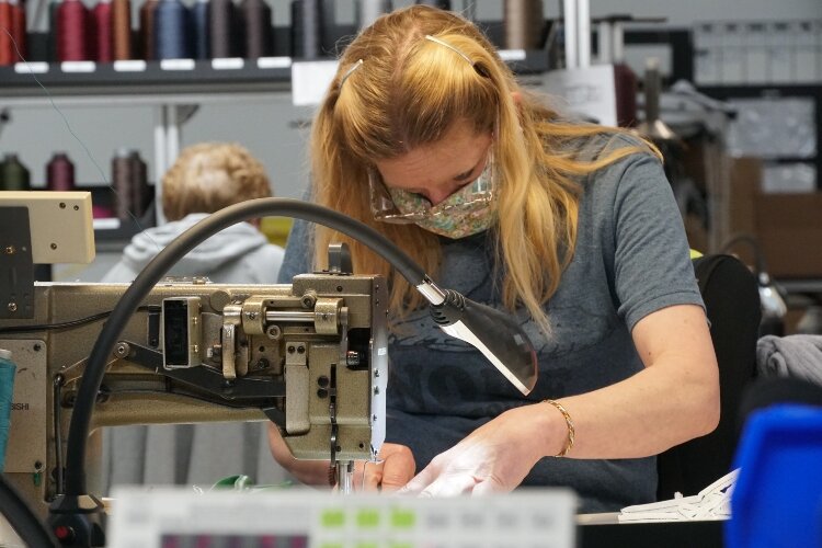 Herman Miller employee sews a mask.