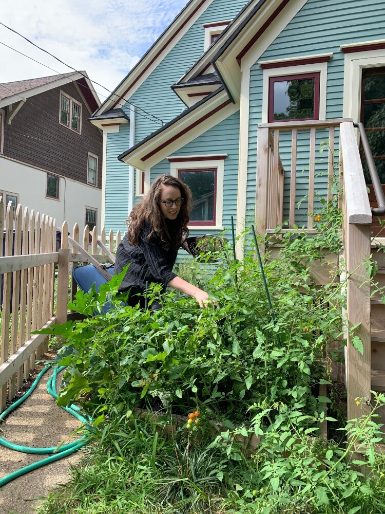 Alyssa Cheadle waters her garden at her home in the Holland Historic District.