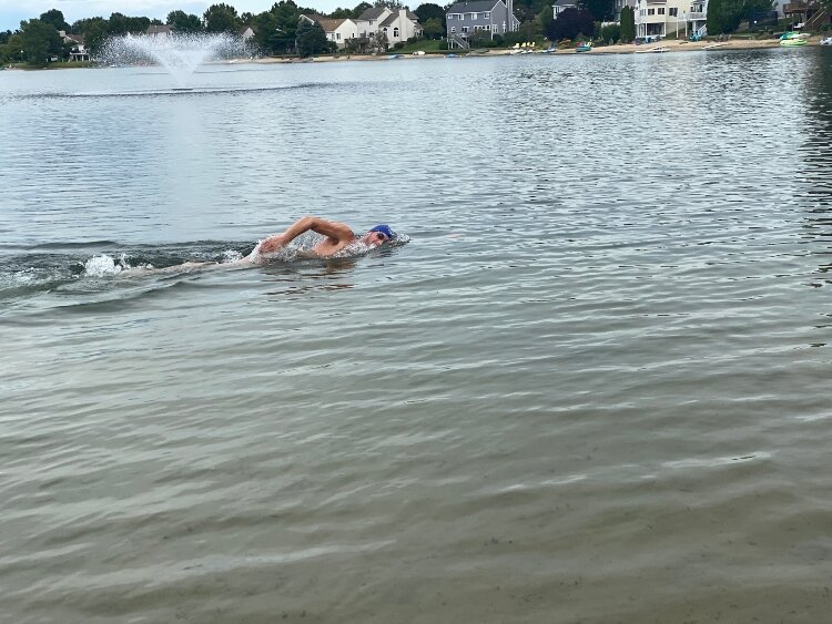 Jeremy Salls practices for the 'Epic Swim' team members in Jon Ornée's Park Township neighborhood pond.