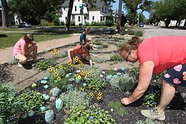 Lori Appeldorn, right, along with her neighbors Raelyn Long, 9, Bentley Weeks, 7, and Reese Weeks, 11, work on the labyrinth garden on the corner of 18th Street and Central Avenue in Holland.