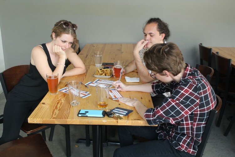 Next 40 professionals enjoying a good conversation at Atwater Brewery during trivia.