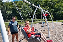 Benjamin's Hope friends enjoying the accessible swing set at the Park Township campus.