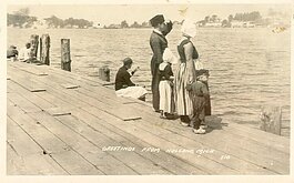 An early post card with a photograph shot from the docks of "Black Lake," what came to be known as Lake Macatawa, shows a family in traditional Dutch costume.