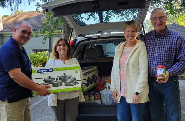 Greg Costa gives Sherry Martens of Resilience a donation for a women's shelter. Local boaters Rick and Rhonda Spykman donated items on the nonprofit's wish list. 