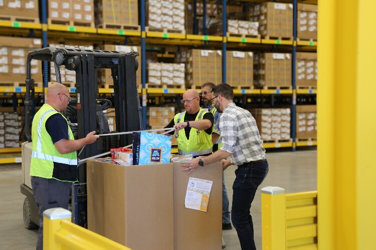 Gentex warehouse employees move a pallet of cereal donations for Community Action House.