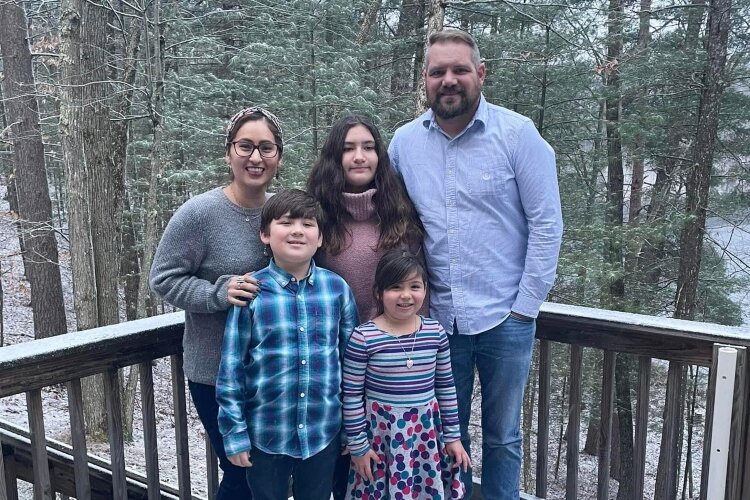 Mitch and Johally Carlson pose with their children outside their new home. The family has a home of their own this holiday season with the help of Lakeshore Habitat for Humanity.