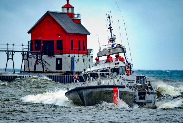 A Coast Guard boat rides by the Grand Haven Lighthouse. (Todd Reed)
